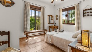 A bedroom with a bed, a desk, a chair, a ceiling fan, and windows with curtains. - Country House 'Villa Pinale Álora' with Mountain View, Wi-Fi and Air Conditioning (Álora)