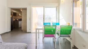 Un appartement moderne doté d’une cuisine, d’un coin repas et d’un balcon offrant une vue agréable.