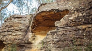 A natural rock formation with a cave-like opening. - Bus & Hot Tub Secluded Eco Forest Retreat (Dysart)
