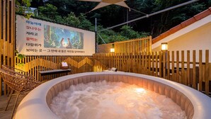 Ein Whirlpool mit Holzzaun und einem Poster im Hintergrund.