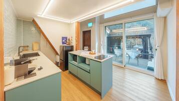A modern kitchen with a built-in island, a dining area with a view, and a sliding glass door leading to an outdoor deck.