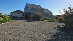 A two-story house with a gravel driveway and a small garden.