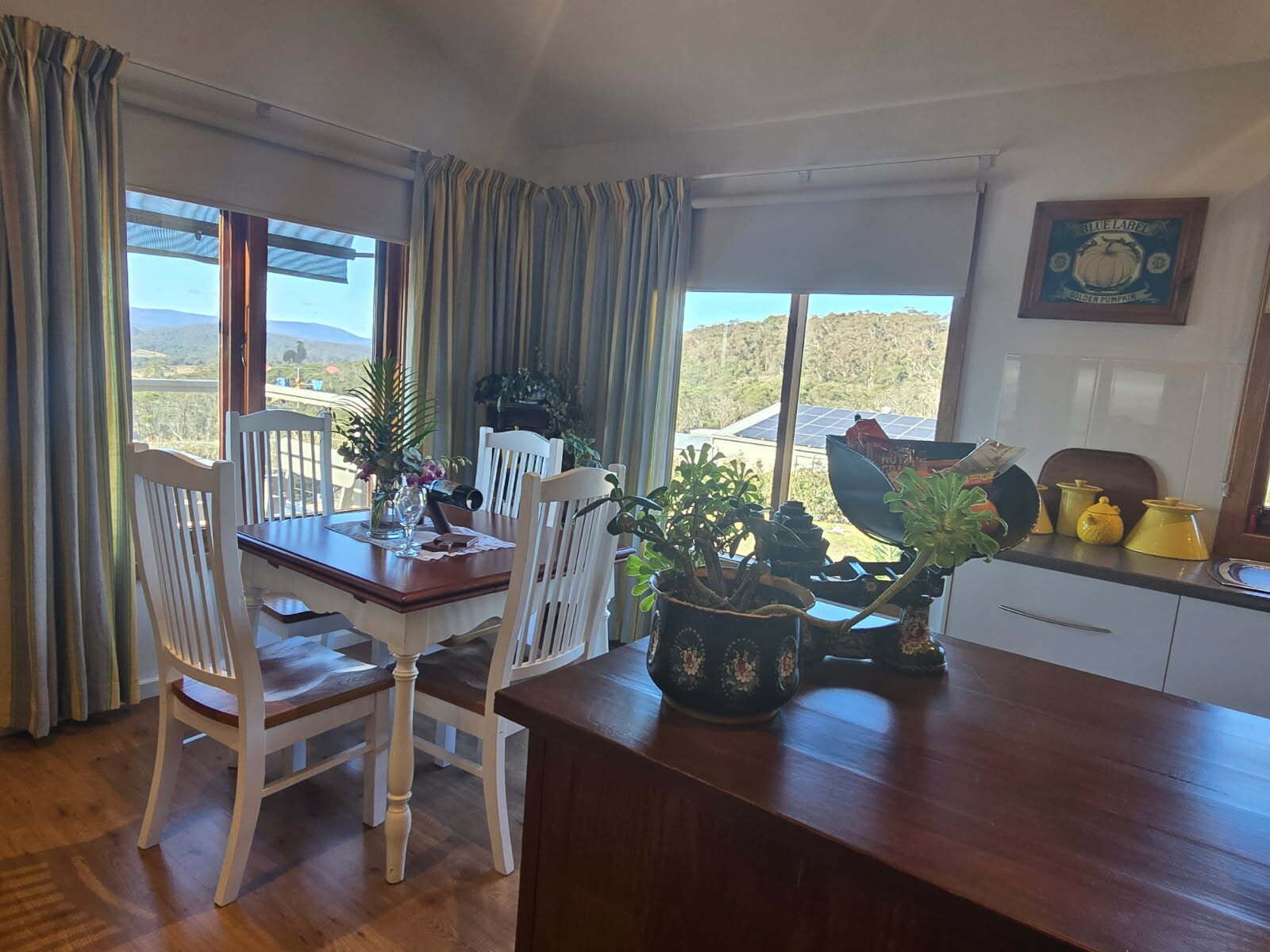 A dining area with a table, chairs, and a view of the outdoors.