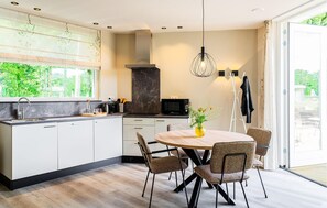 Enjoy cooking in this well-lit kitchen with a central island and a view of the surrounding greenery.