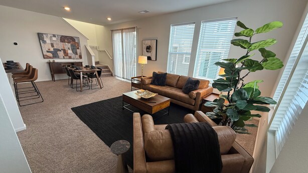 Een moderne woonkamer met een bank, salontafel en eethoek.