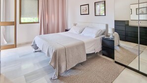 A modern bedroom with a bed, nightstand, and a large mirror. - Nice apartment in Malaga with swimming pool (Malaga)