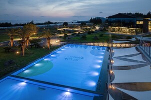 Una piscina al aire libre de temporada, sombrillas