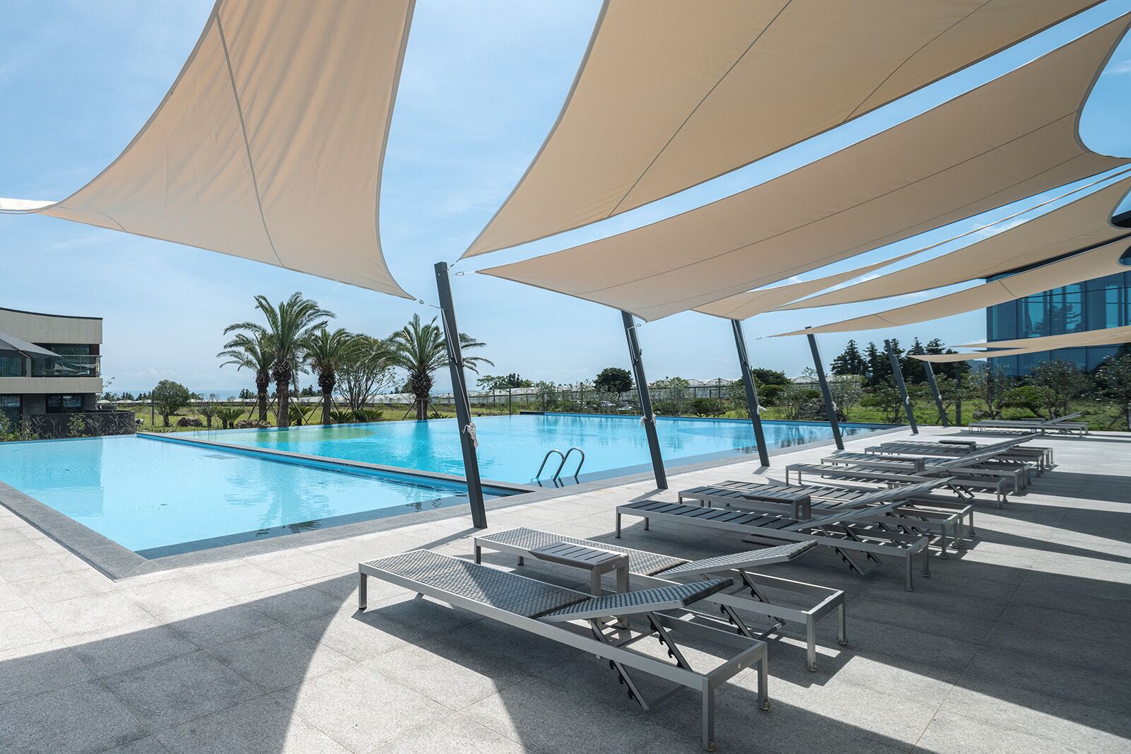 حمّام سباحة خارجي موسمي، مظلات على حمّام السباحة، مقاعد للتشمس