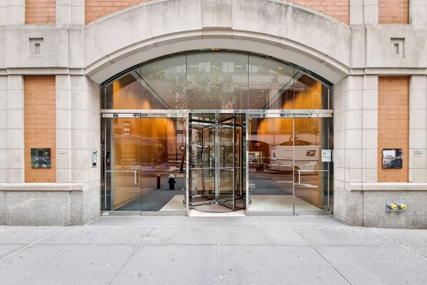 A building entrance with a glass door and a revolving door.