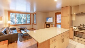 Una cocina moderna con una isla central, armarios de madera y un horno Bosch.