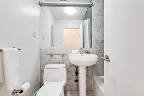 A bathroom with a toilet, sink, and shower.