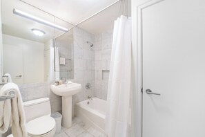 A bathroom with a toilet, sink, and bathtub.