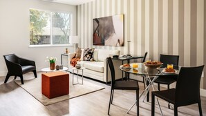 A modern living room with a glass dining table, a sofa, and a coffee table. - Silicon Valley One Bedroom with Terrace (Sunnyvale)