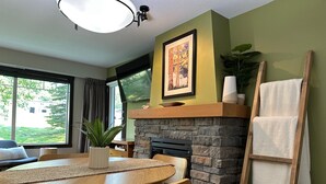 Un comedor con chimenea de piedra, una mesa de madera y sillas.