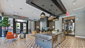 A modern interior with a central island, seating area, and a patterned floor.