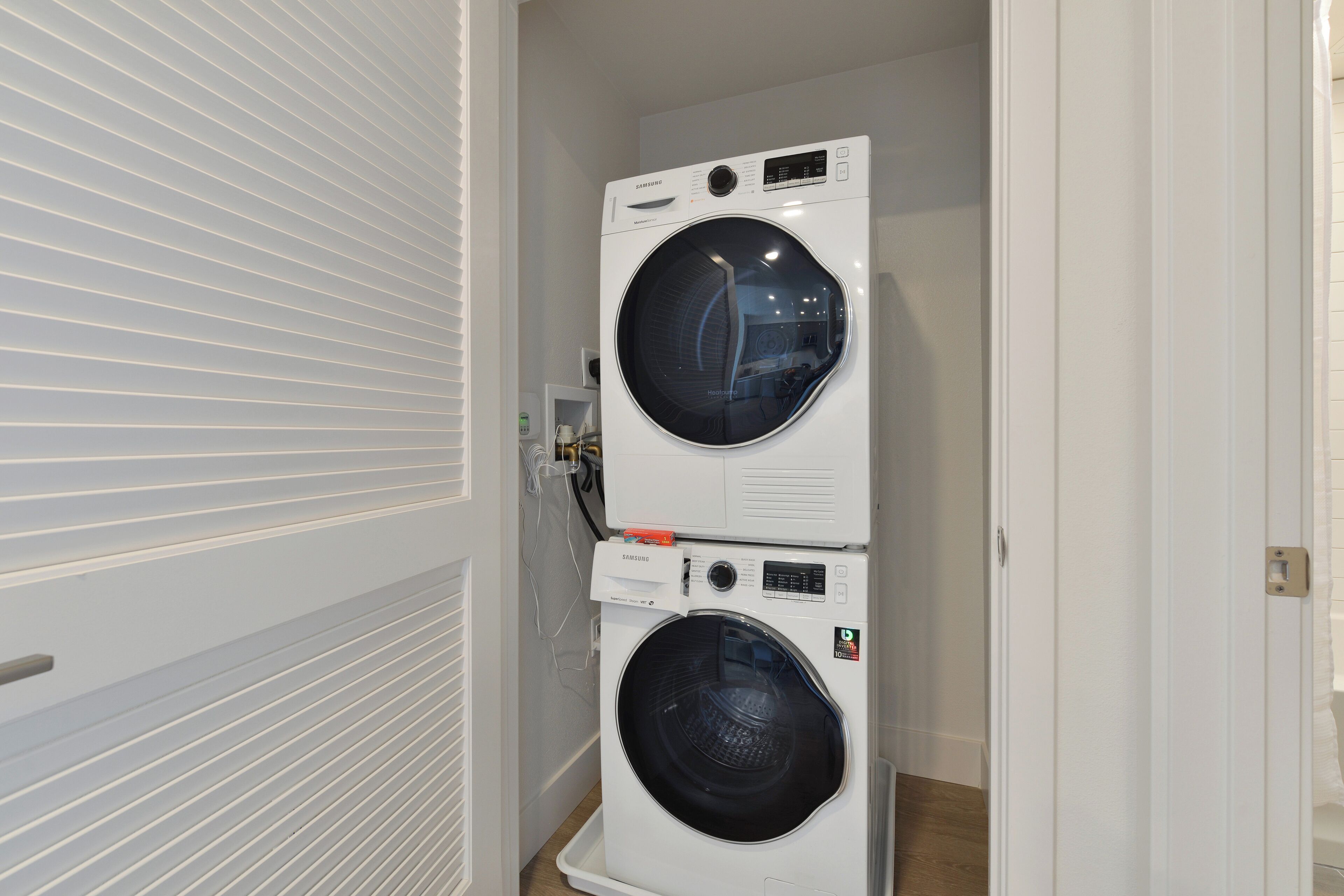 A laundry room with two stacked front-loading washing machines.