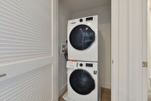 Une buanderie équipée de deux machines à laver à chargement frontal superposées.