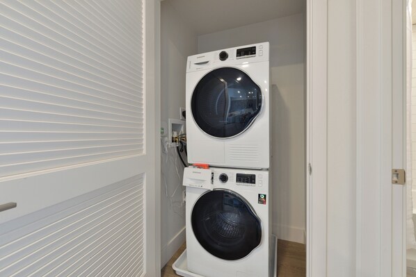 A laundry room with two stacked front-loading washing machines.