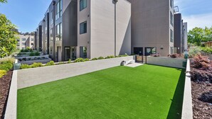 Un edificio moderno con techo plano, ventanas grandes y un césped bien cuidado.