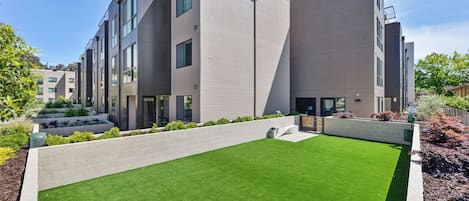 A modern building with a flat roof, large windows, and a well-maintained lawn.
