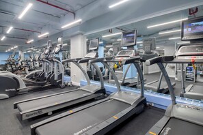 Un gimnasio con cintas de correr y equipo de ejercicio.
