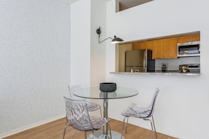 A modern kitchen with wooden cabinets, a stainless steel refrigerator, and a microwave. - Bright Midtown West Living | W/D, Fitness Center (New York)