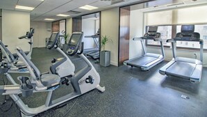 Un gimnasio con cintas de correr, elípticas y bicicletas estáticas.