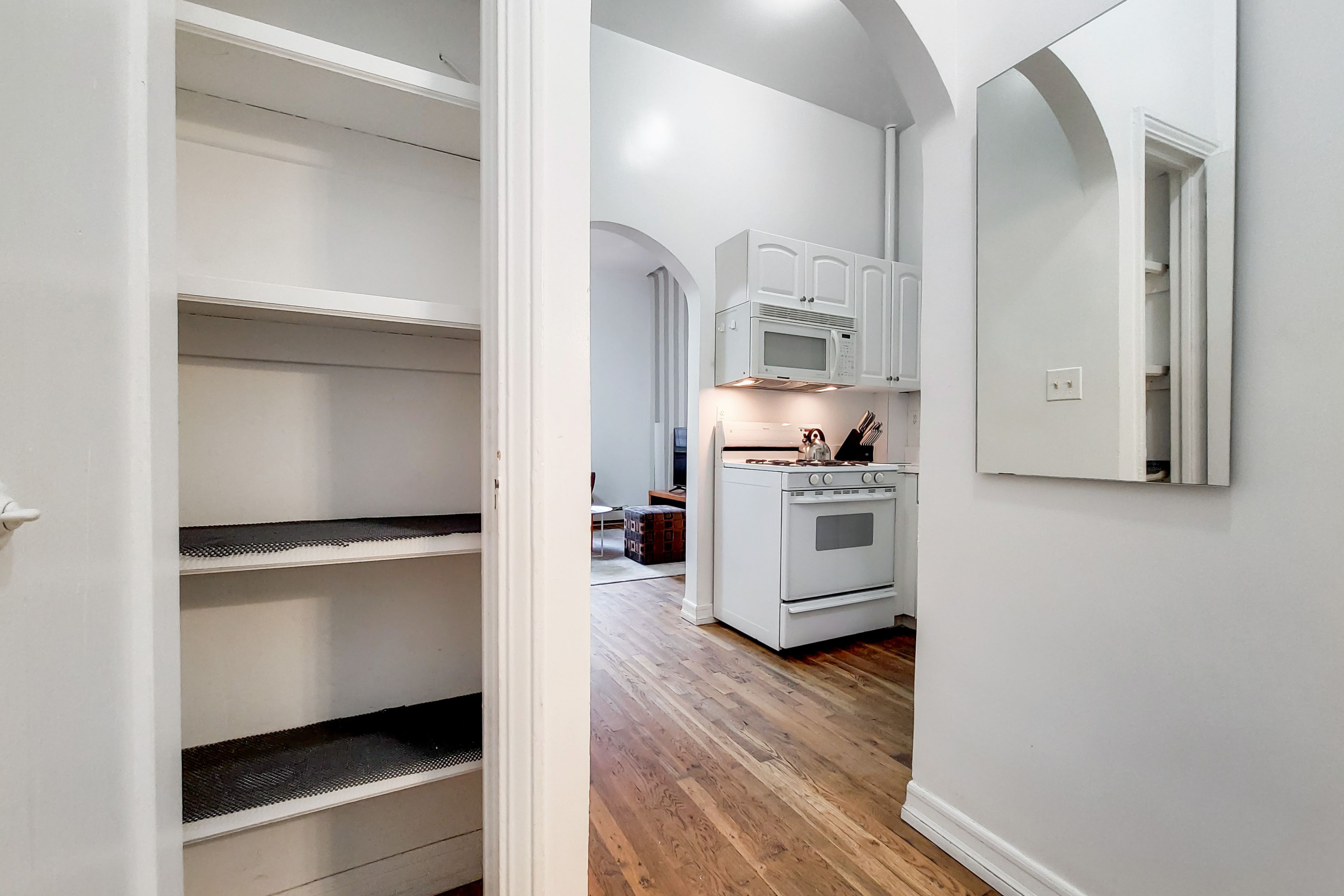 A kitchen with white cabinets, a microwave, and an oven.