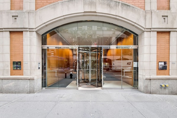 A building entrance with a glass door and a revolving door.