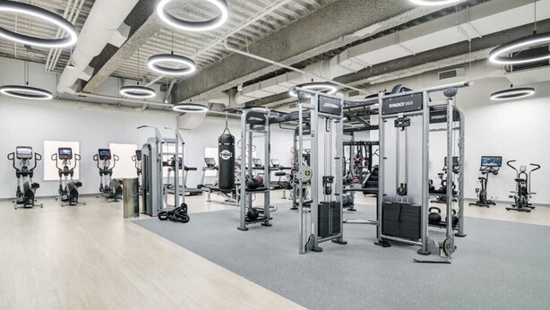 Uma academia com diversos equipamentos de exercício, incluindo esteiras e aparelhos de musculação.