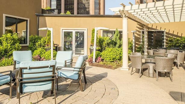 Uma área de estar ao ar livre com disposição de assentos e uma estrutura de pérgola.