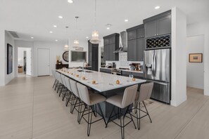 A modern kitchen with a central island, stainless steel appliances, and pendant lighting. - Pecan Valley 5205/5193|2 Private Pools&Spas, Private Pickleball Court, Game Room (Hurricane)