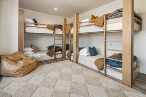 A room with bunk beds, a sofa, and a patterned rug. - Pecan Valley 5205/5193|2 Private Pools&Spas, Private Pickleball Court, Game Room (Hurricane)