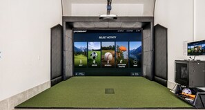 A room with a large screen displaying a sports activity selection menu.