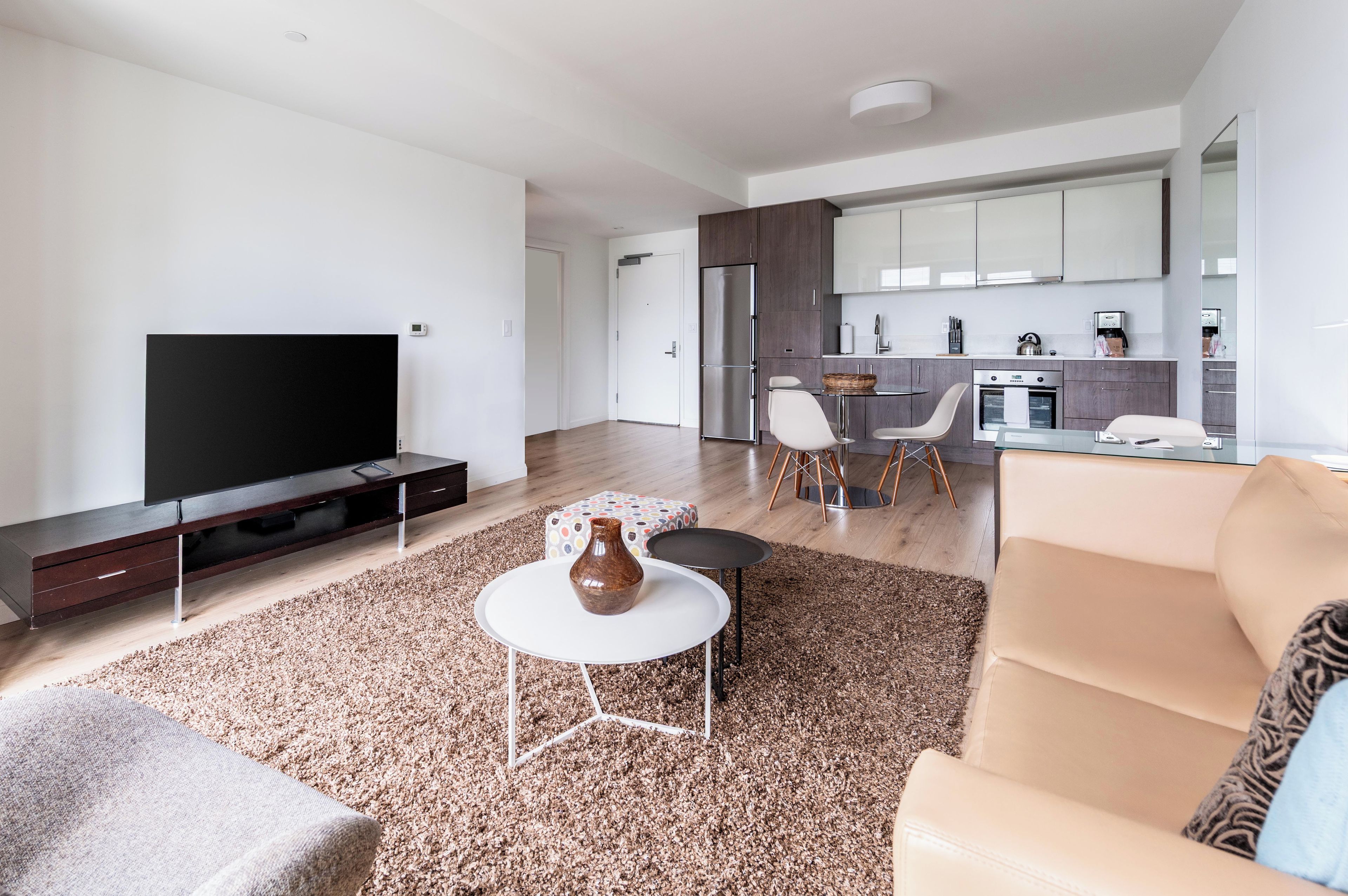 A modern living room with a flat-screen TV, a coffee table, and a sofa.