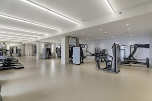 Un'ampia palestra con diverse macchine per esercizi e uno specchio grande.