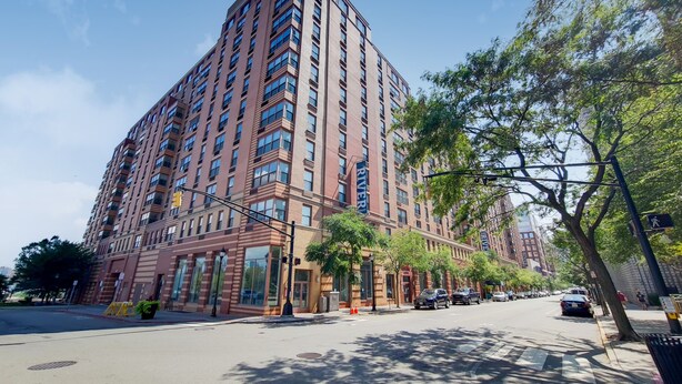Un edificio alto con varios pisos, ventanas amplias y una entrada destacada.
