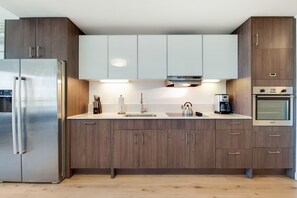 A modern kitchen with stainless steel appliances, wooden cabinets, and a central island.