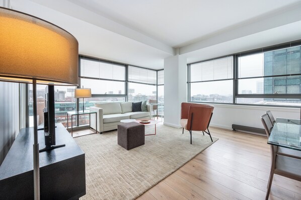 A modern living room with a sofa, coffee table, and a glass table with chairs.