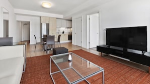 A modern apartment with a living room, dining area, kitchen, and a TV. - Spacious One Bedroom, Steps from Fenway Park (Boston)