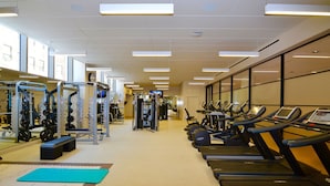 A gym with treadmills, weight machines, and a mirrored wall. - Spacious One Bedroom, Steps from Fenway Park (Boston)