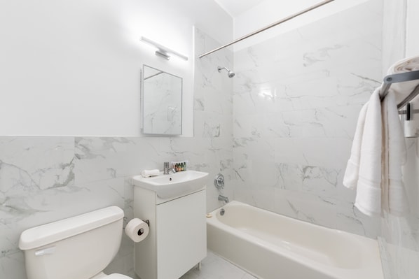 A bathroom with a toilet, sink, and bathtub.