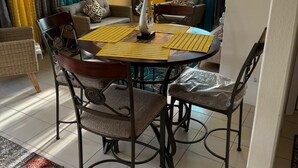 Een eetruimte met een ronde tafel, vier stoelen en een plafondventilator.