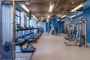 A gym with treadmills, weight machines, and exercise equipment.