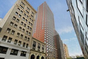 A high-rise building with a modern architectural design, featuring a mix of brick and glass facades.
