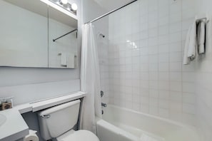 Ein modernes Badezimmer mit Toilette, Waschbecken, Spiegel, Dusche und Badewanne.