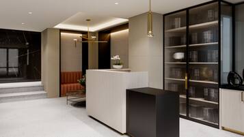 A modern reception area with a reception desk, seating, and a bookshelf.