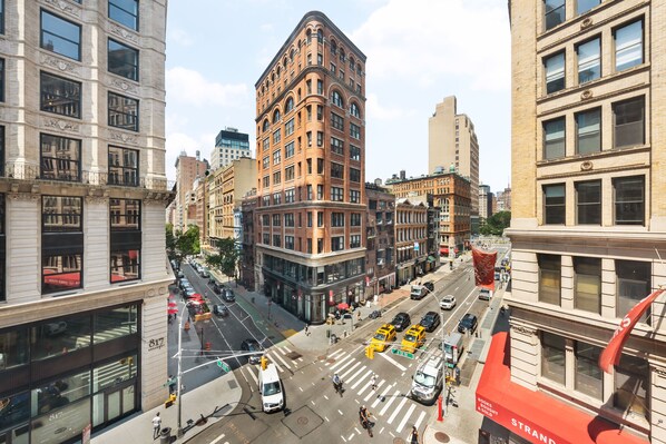 A city street with buildings, vehicles, and pedestrians.