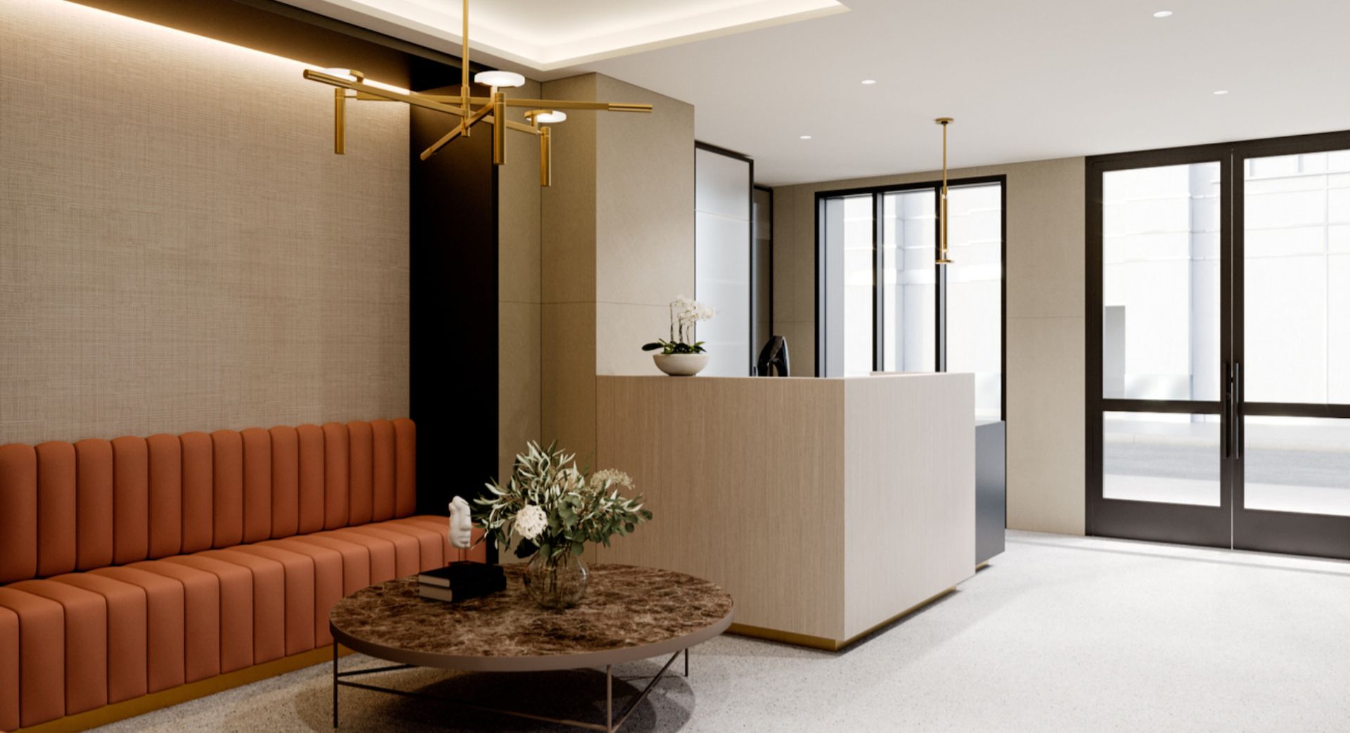 A modern reception area with a sofa, a round table with a vase of flowers, and a reception desk.