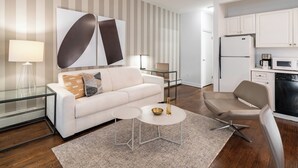 Ein modernes Wohnzimmer mit einer Couch, einem Couchtisch und einem Essbereich mit einem Stuhl.